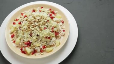 Tavuk, ananas, nar ve fındıklı bir tabak salata daire şeklinde döner. Ortam planı