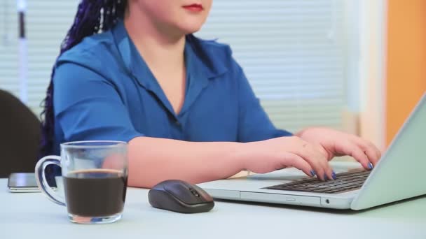 Woman with blue afro braids without a face in the office works at a laptop — Stock Video