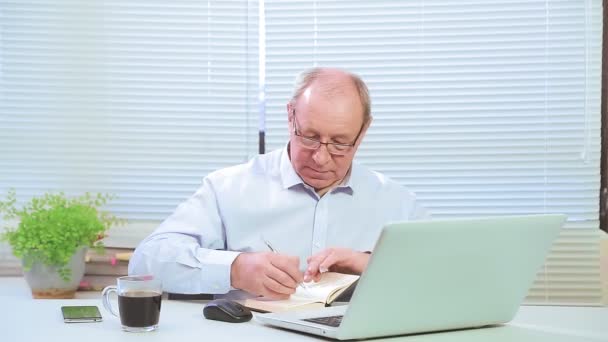 Líder masculino com óculos no escritório nas obras de computador e com projetos. — Vídeo de Stock