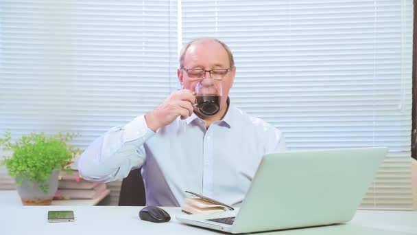 O homem no escritório permaneceu depois do trabalho bebendo café para ficar acordado. — Vídeo de Stock