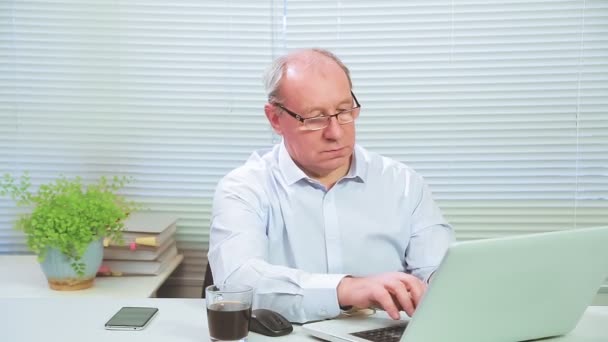 Male supervisor with glasses in the office at the computer works — Stock Video