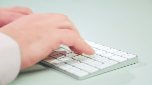 Vista lateral das mãos masculinas estão digitando em um teclado branco — Vídeo de Stock