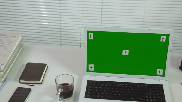办公室百叶窗和笔记本电脑绿色屏幕放在桌子上，桌上有工作项目 — 图库视频影像