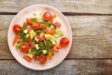 Somon ve kiraz domatesli salata ve ahşap bir masada yeşil salata. Uzayı kopyala Yatay fotoğraf