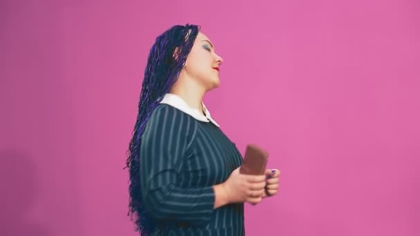 穿着蓝色非洲辫子的时髦的黑发女郎手拿着电话跳舞 中期计划 — 图库视频影像