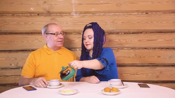 自宅のテーブルで夫婦とアフロヘアの女性が注ぎ お茶を飲む 計画全体 — ストック動画