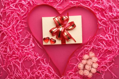 On a pink background, a voluminous heart made of paper and pebbles and ribbons and a bunch of roses decor inside a gift. clipart