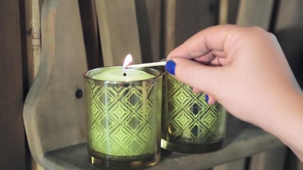 Womans hand holds a match and lights candles in the spa. — Stock Video