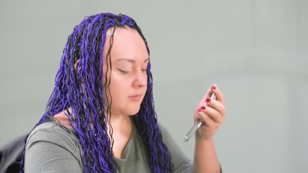 Kobieta w biurze z niebieskimi afro fryzury maluje oczy z cieniami — Wideo stockowe