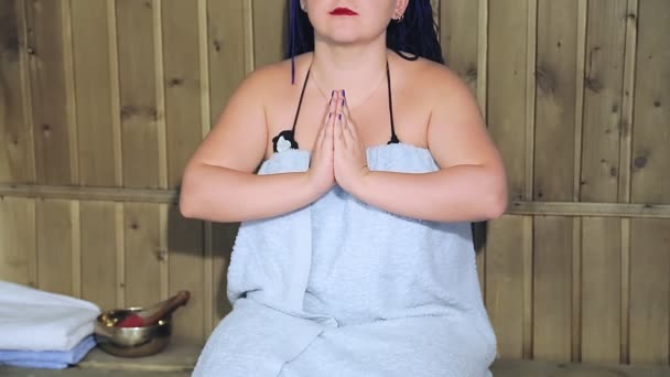 Žena ve vaně v ručníku bez tváře medituje v namaste