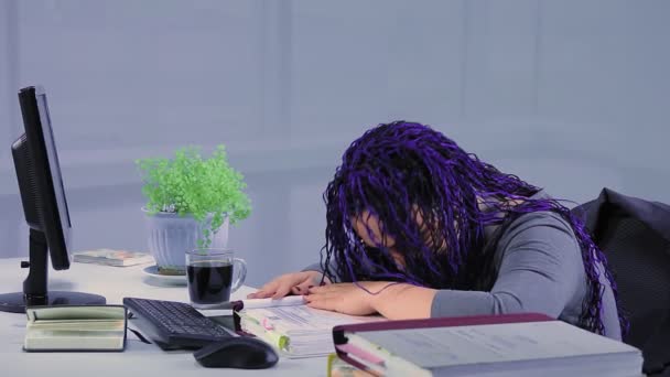 Femme fatiguée avec des tresses afro bleues dans le bureau regardant à travers les rapports luttant contre la somnolence — Video