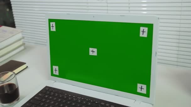 Tirai kantor dan layar hijau laptop di atas meja dengan alat tulis — Stok Video