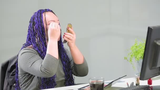Vrouw in kantoor met blauwe afro kapsels schildert ogen met schaduwen — Stockvideo