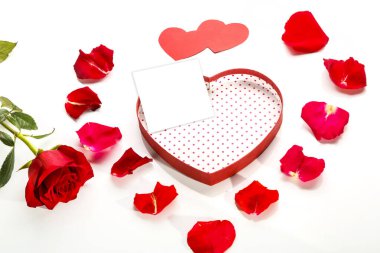 Beyaz arkaplanda kalp şeklinde bir kutuda, gül yapraklarının ortasında bir kartpostal ve güllerin yanında kırmızı kalpler olan bir kartpostal..