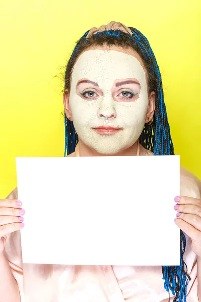 身穿蓝色非洲辫子的犹太妇女，戴着冰冻的绿色粘土面具，手持黄色背景的海报. — 图库照片