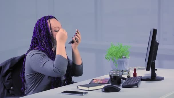 Kobieta z niebieskimi afro warkoczami w biurze maluje oczy cieniami — Wideo stockowe