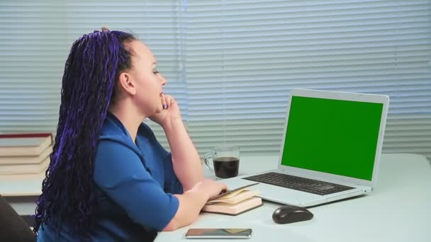 Frau mit blauen Afro-Zöpfen im Büro am Computer, grüner Bildschirm, Schultern tanzend — Stockvideo