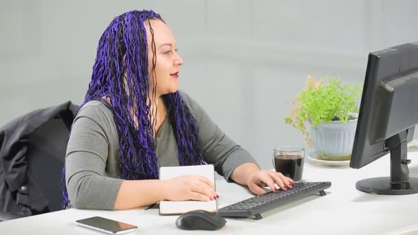 Kobieta w biurze z niebieską fryzurą afro pracuje przy komputerze na konferencji internetowej. — Wideo stockowe