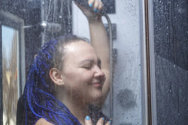 淋浴间里有蓝色非洲式头发的女人用水洗头. — 图库照片
