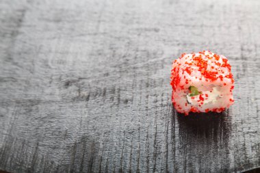Tahta bir masada karides, salatalık ve tobiko havyarla yuvarlan. bir yer kaydet.