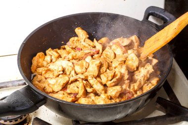 Soya soslu tavuk fileto ve limon suyu tavada ahşap bir spatulayı karıştırıyor. Yatay fotoğraf