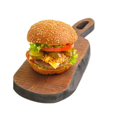 Biftekli klasik burger, soslu peynirli sebze, beyaz arka planda el yapımı ahşap bir tahtanın üzerinde hardal. Yatay fotoğraf