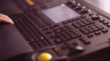 Grand MA konsolunda ışıklandırma tasarımcısı bir kadının resimli editör eli ışıklandırma programlama ile çalışıyor.