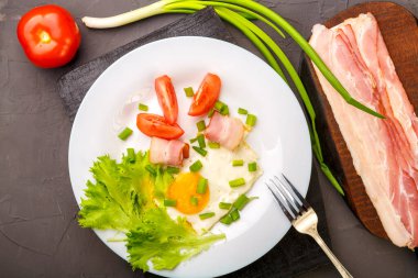 Yağda yumurta, domuz pastırması, domates ve yeşil soğanla süslenmiş pastırma, domates ve soğan dilimlenmiş..