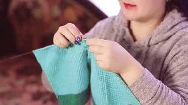 Yüzü olmayan bir kadın elinde örgü iğneleriyle akşamları örgü örer.