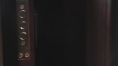 Bir adam anahtarı tutar ve deliğe sokarak kapıyı kilitler.