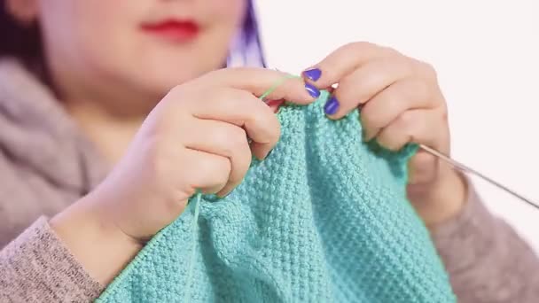 A woman holds knitting needles in her hands and knits a sweater with a patterned pattern — Stock Video