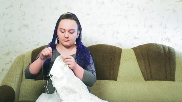Νύφη Στο Σπίτι Στον Καναπέ Ράβει Νυφικό Της Χέρι Βελόνα — Αρχείο Βίντεο