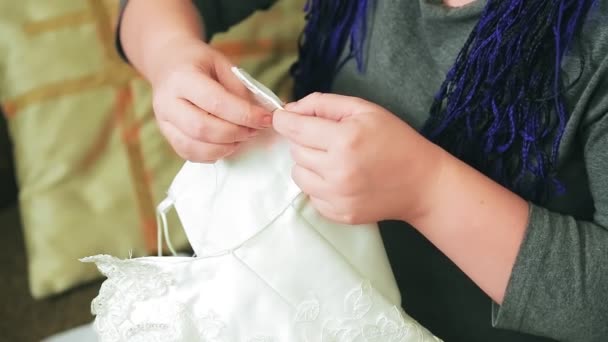 花嫁は針と糸で彼女の結婚式のドレスを手で見た 中期計画 — ストック動画
