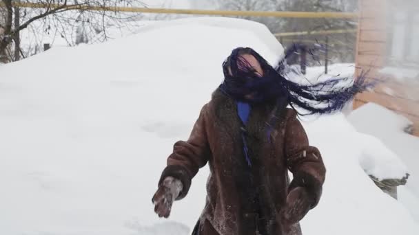 アフロ編組の暖かいコートを着た幸せな女性が雪を投げます 計画全体 — ストック動画