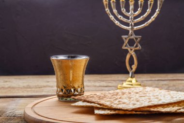Yuvarlak ahşap bir tahtanın üzerinde bir şamdan ve masanın yanında bir bardak kiraz şarabı var. Yatay fotoğraf