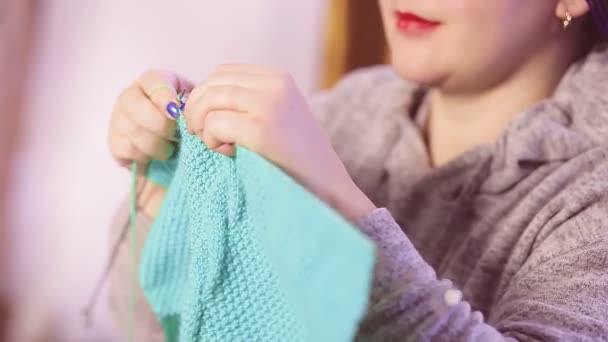 Una donna che scatta foto senza un viso tiene aghi per maglieria tra le mani e maglia un maglione con un modello semplice — Video Stock