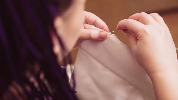 Femmes mains avec une aiguille et fil coudre une robe de mariée faite à la main — Video