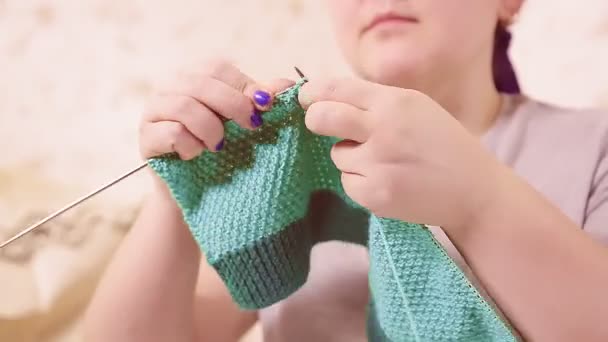 Breinaalden in de handen van vrouwen breien een trui van lichte wol — Stockvideo