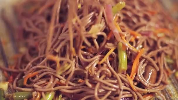 Tongs yuerut Soba com cogumelos e legumes em molho — Vídeo de Stock