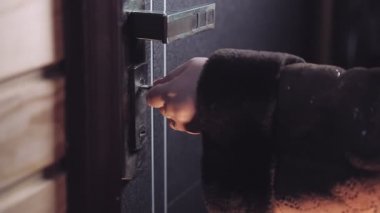 Kadın eli anahtarı anahtar deliğine sokar kapıyı açar ve kadın içeri girer.