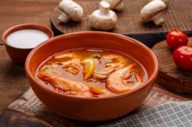 Tom yer elması çorbası, masada karidesler, peçete, hindistan cevizi sütü mantarları ve domateslerin yanında..