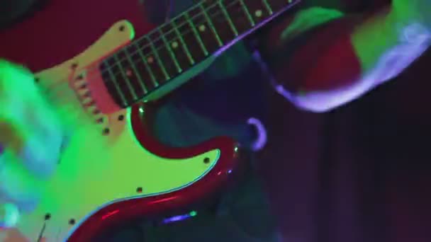 ネオンライトの男性の手はコンサートでエレキギターを演奏 — ストック動画