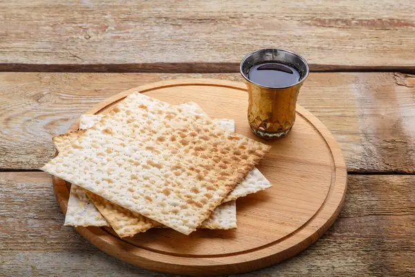 Yuvarlak ahşap bir tahta matza ve bir bardak kiraz şarabı üzerinde.