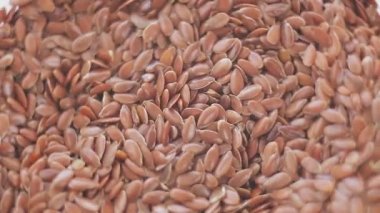 Brown flax seeds rotate in a circle macro