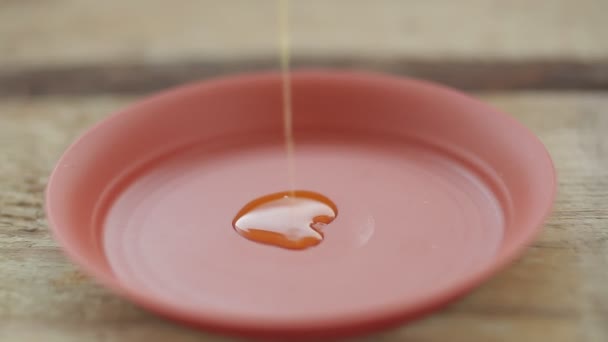 Leinöl wird in einem dünnen Strahl in einen Teller gegossen. — Stockvideo