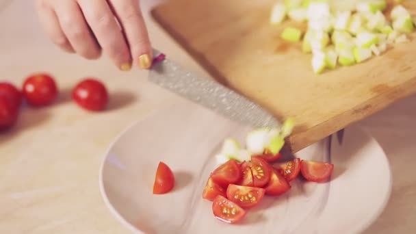 A nők kézzel dolgoznak, zöld almát szeletelnek egy tányér salátába.. — Stock videók