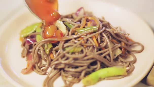 Lepel schenkt Thaise saus op soba met champignons en groenten — Stockvideo