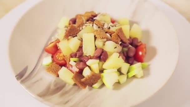 Salada vegetal tailandesa com abacaxi e croutons em uma chapa gira em um círculo — Vídeo de Stock