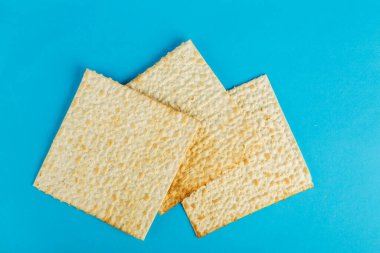 Matzo tabakları mavi arka planda her şekilde serilmiştir. Yatay fotoğraf