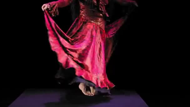Een blote voeten zigeuner vrouw zonder gezicht met lang zwart haar in een rood pak danst brandend tegen een zwarte achtergrond — Stockvideo